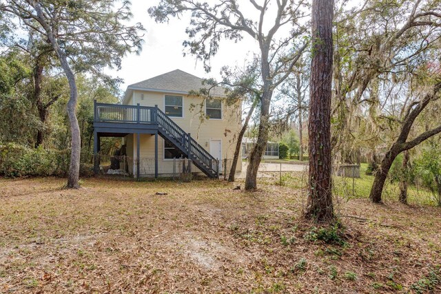 rear view of property featuring stairs and a deck