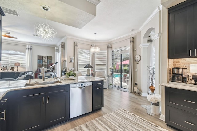 kitchen featuring an inviting chandelier, hanging light fixtures, stainless steel dishwasher, and sink