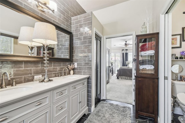 bathroom featuring ceiling fan, tile walls, vanity, decorative backsplash, and toilet