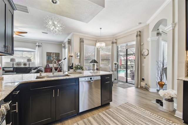 kitchen with light wood-style flooring, a sink, crown molding, and stainless steel dishwasher