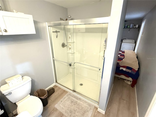 13215 Seminole Trl, Wimauma, FL 33598 - bathroom featuring a shower with door, toilet, hardwood / wood-style flooring, and washer / clothes dryer