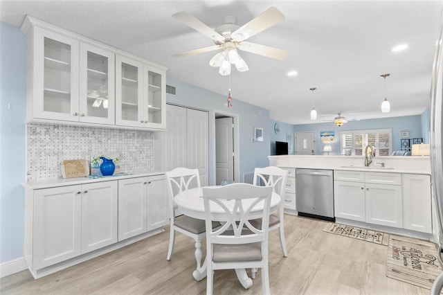 kitchen featuring pendant lighting, sink, white cabinetry, and stainless steel dishwasher