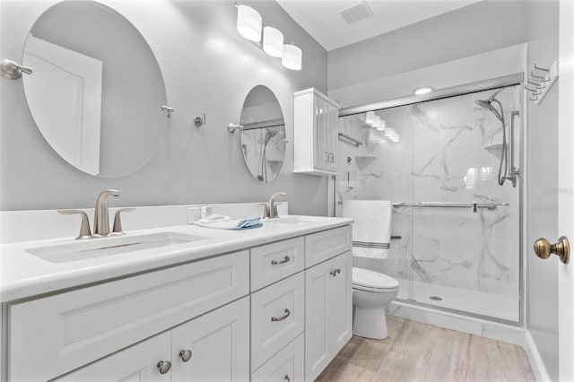 bathroom with wood-type flooring, toilet, vanity, and walk in shower