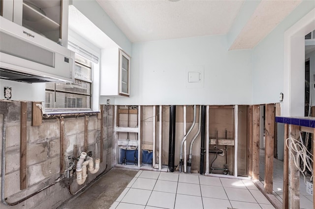 kitchen featuring white cabinetry, a textured ceiling, and light tile patterned flooring