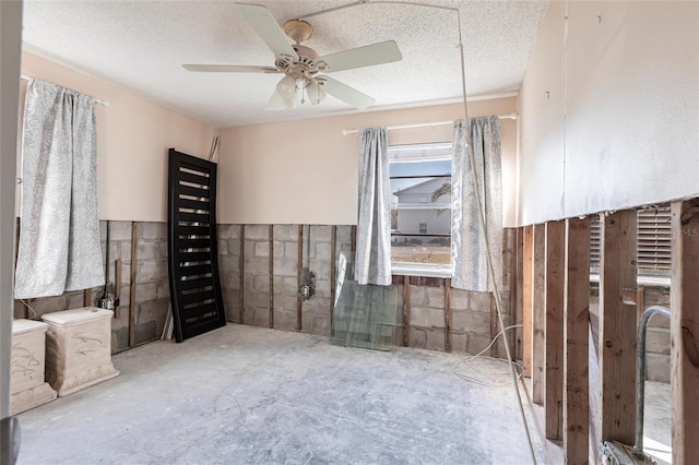 interior space featuring ceiling fan, concrete floors, and a textured ceiling