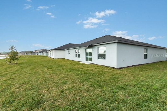 rear view of house featuring a lawn