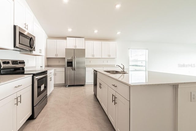 kitchen featuring a kitchen island with sink, sink, stainless steel appliances, and white cabinets