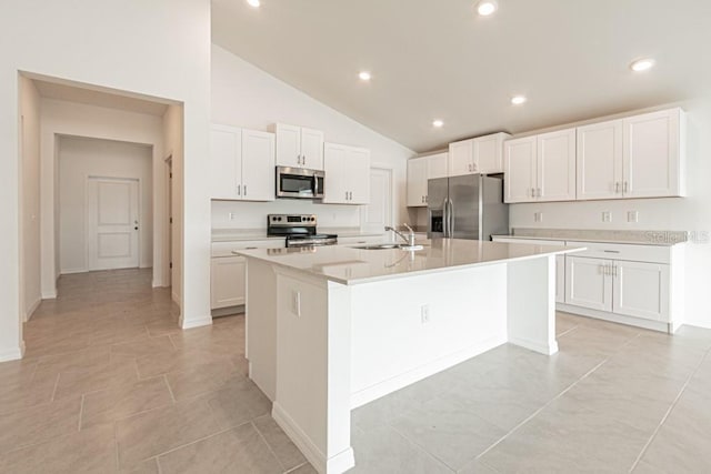 kitchen featuring sink, appliances with stainless steel finishes, high vaulted ceiling, white cabinets, and a center island with sink