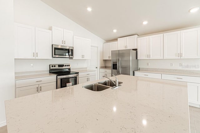 kitchen featuring light stone counters, appliances with stainless steel finishes, and sink