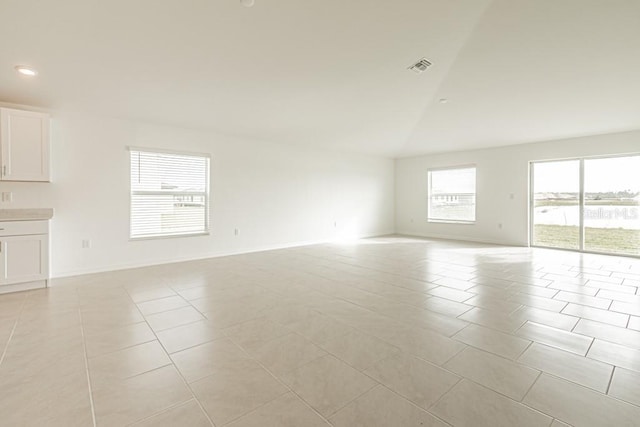 spare room with lofted ceiling and light tile patterned floors