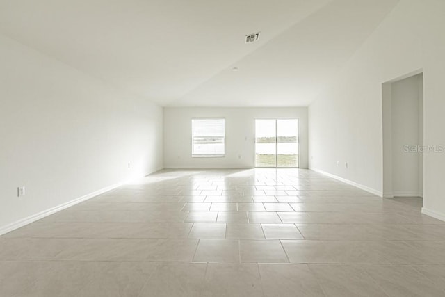 tiled empty room featuring high vaulted ceiling