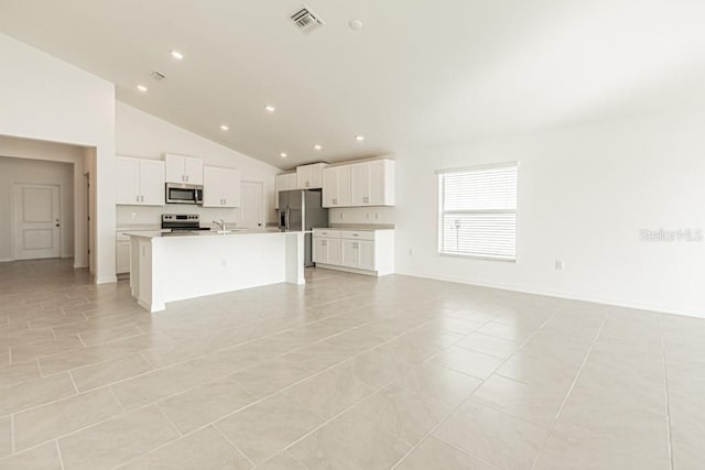 kitchen with stainless steel appliances, light tile patterned floors, a center island with sink, and white cabinets