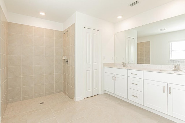 bathroom with vanity, tile patterned flooring, and a tile shower