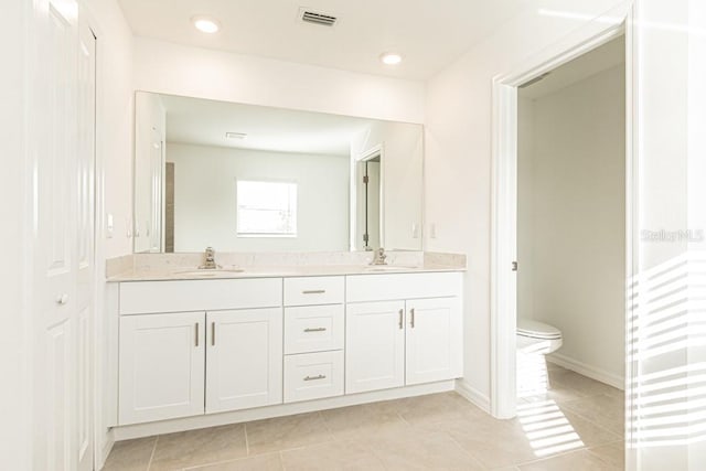 bathroom featuring tile patterned flooring, vanity, and toilet