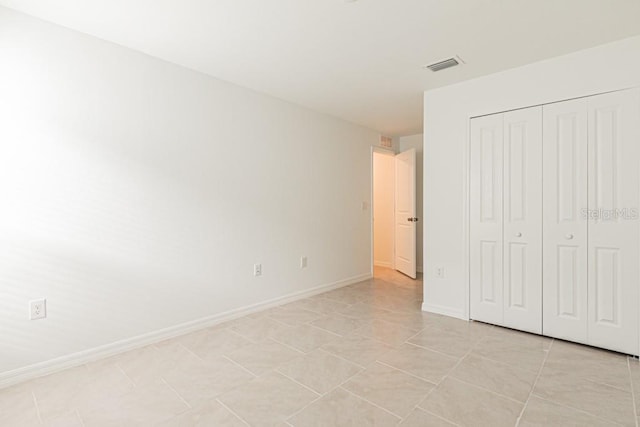 unfurnished bedroom featuring a closet and light tile patterned floors