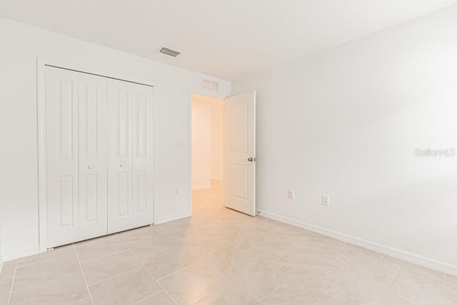 unfurnished bedroom with light tile patterned floors and a closet