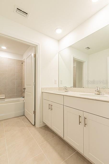 bathroom with tiled shower / bath, vanity, and tile patterned flooring