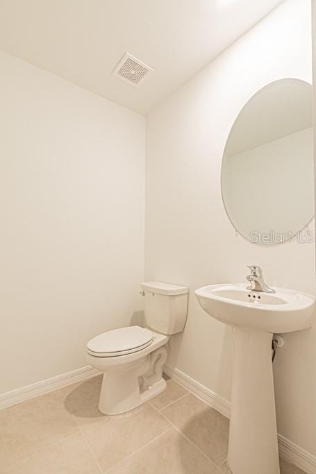 bathroom featuring sink, tile patterned floors, and toilet