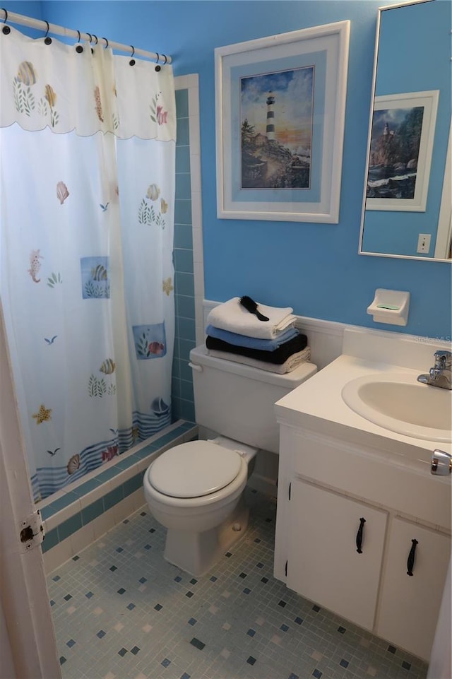 bathroom with vanity, tile patterned flooring, toilet, and walk in shower