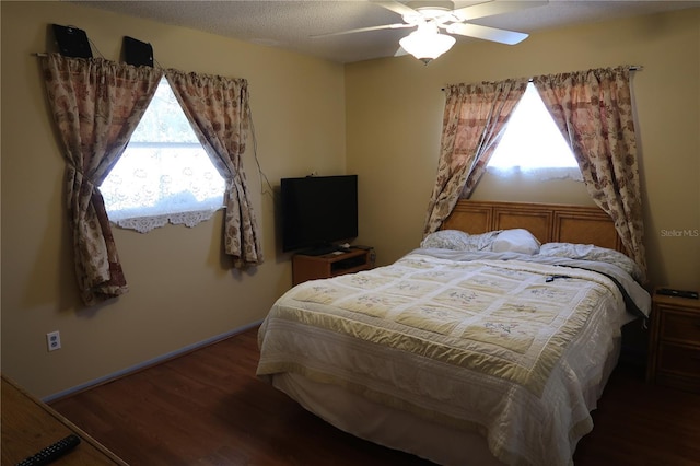 bedroom with dark hardwood / wood-style floors, a textured ceiling, and ceiling fan