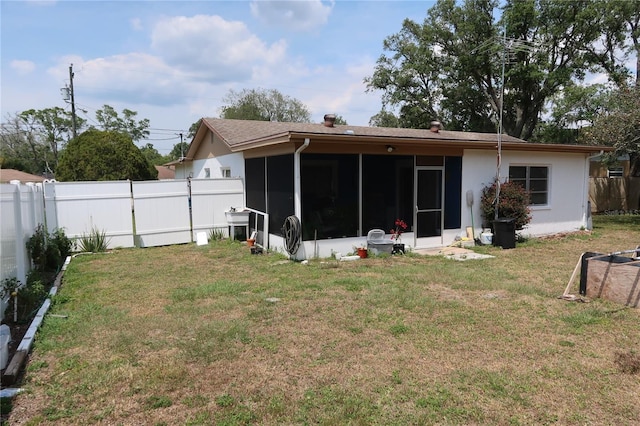 back of house featuring a sunroom and a lawn