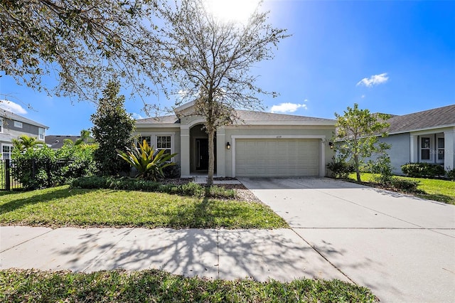 single story home with a garage and a front lawn