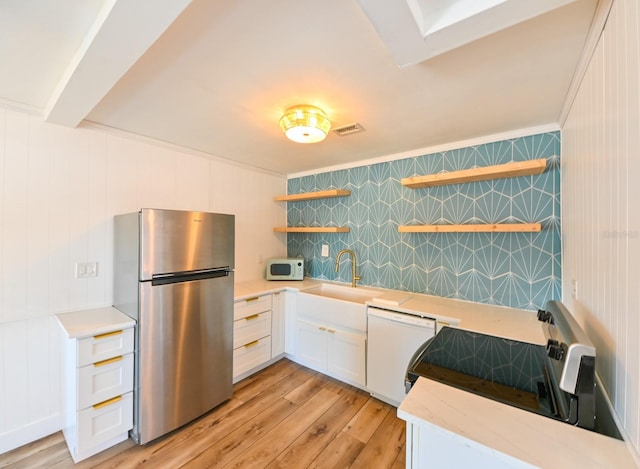 kitchen with sink, white cabinets, ornamental molding, white appliances, and light hardwood / wood-style flooring