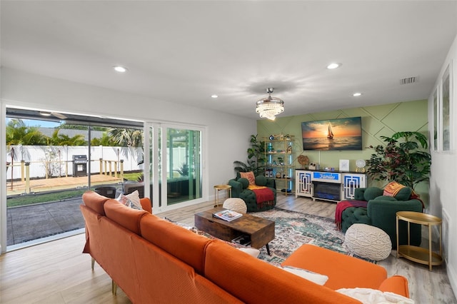 living room featuring a chandelier and light hardwood / wood-style flooring