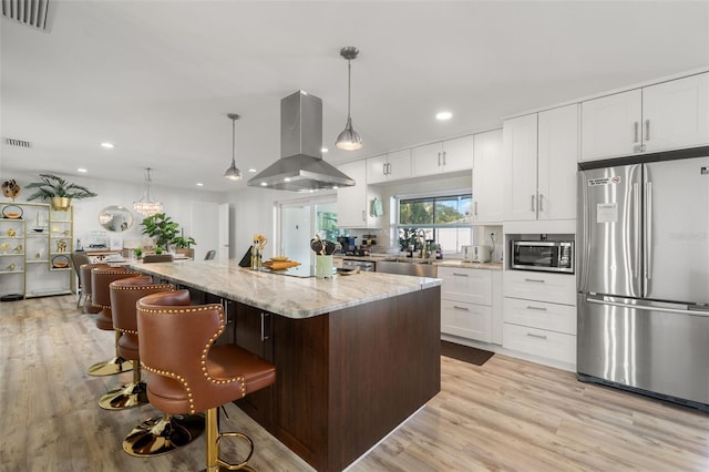 kitchen featuring appliances with stainless steel finishes, a center island, island range hood, and white cabinets