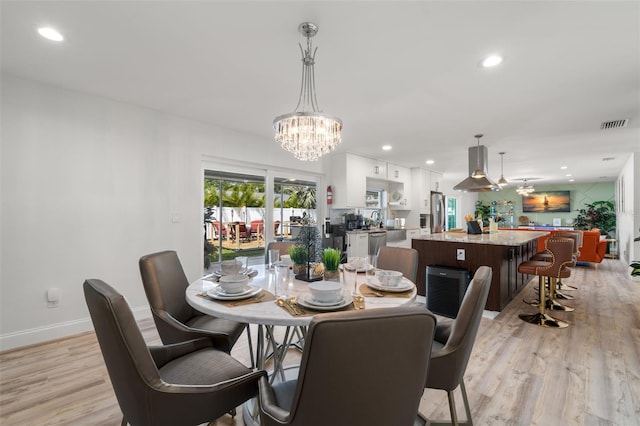 dining area featuring an inviting chandelier and light wood-type flooring