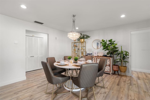 dining space featuring a notable chandelier and light wood-type flooring