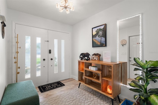 entrance foyer with an inviting chandelier and light hardwood / wood-style floors