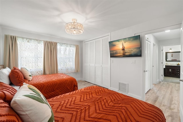 bedroom with ensuite bathroom and light wood-type flooring