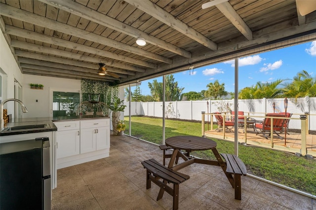 sunroom / solarium with wood ceiling, beam ceiling, and sink