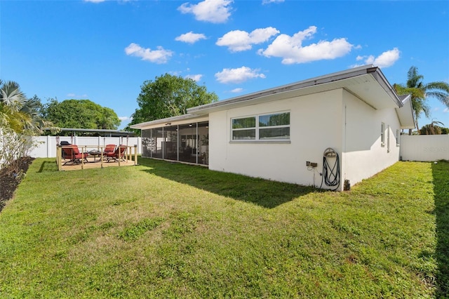 rear view of property featuring a yard, a patio area, and a sunroom