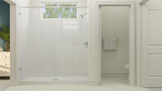 bathroom featuring a shower with door and toilet