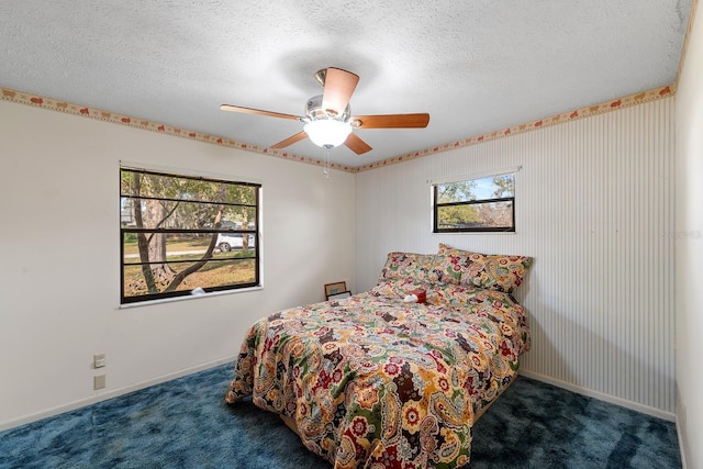 carpeted bedroom with ceiling fan and a textured ceiling