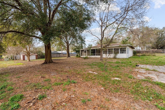 view of yard with a sunroom and a storage unit