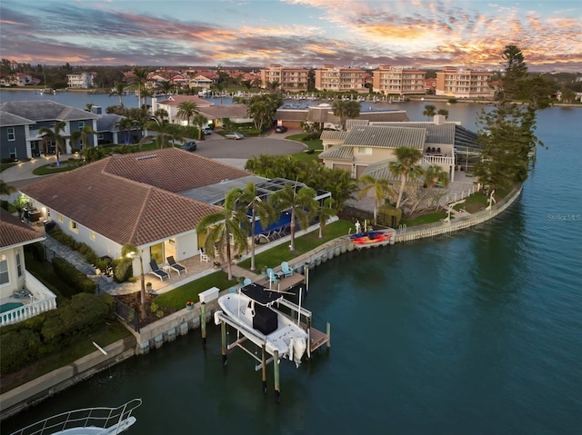 aerial view at dusk featuring a water view