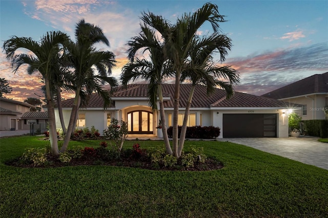 view of front of property with a yard and a garage