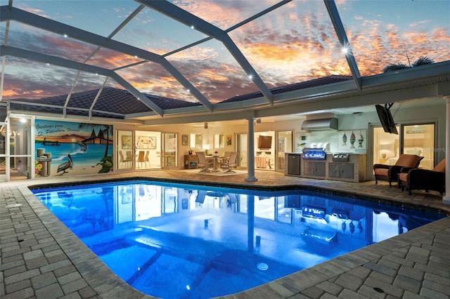 pool at dusk with area for grilling, a grill, a patio, and glass enclosure