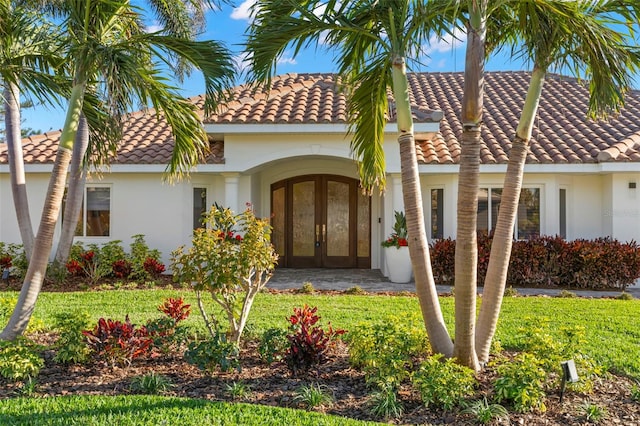 mediterranean / spanish-style home with french doors and a front yard