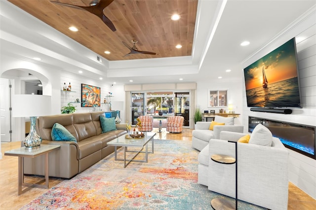 living room featuring wood ceiling, ceiling fan, and a tray ceiling