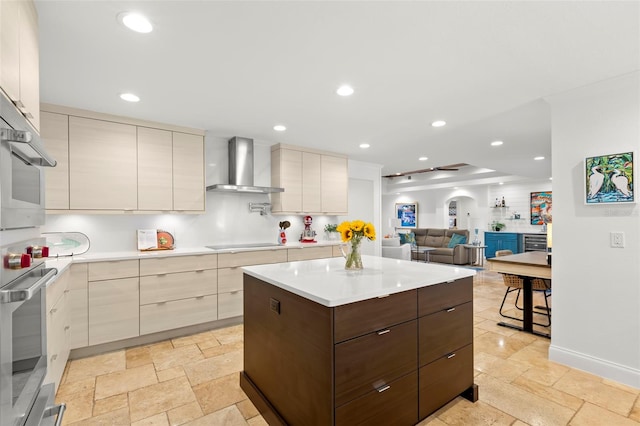 kitchen with dark brown cabinetry, a kitchen island, black electric cooktop, oven, and wall chimney exhaust hood