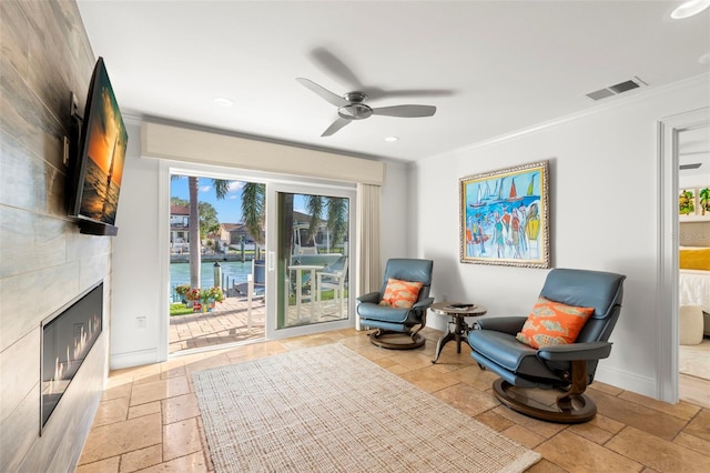 sitting room with ceiling fan and ornamental molding