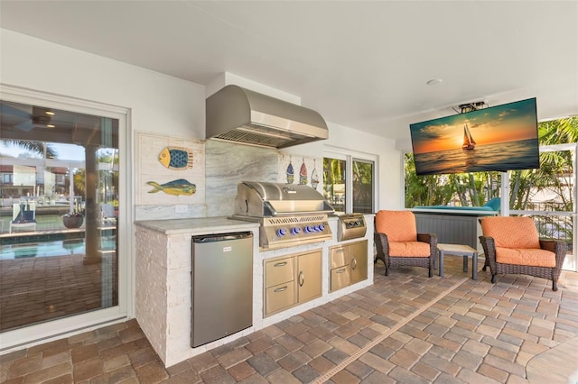 kitchen featuring extractor fan, light brown cabinetry, stainless steel refrigerator, and decorative backsplash