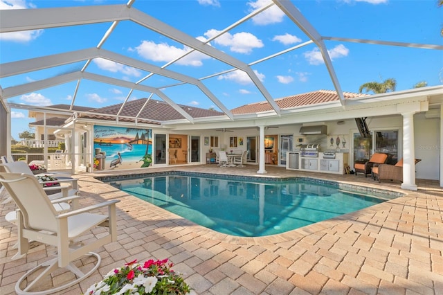 view of pool featuring an outdoor kitchen, a grill, a lanai, and a patio