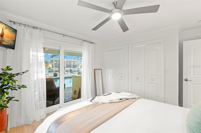 bedroom with ornamental molding, access to exterior, ceiling fan, light hardwood / wood-style floors, and multiple closets