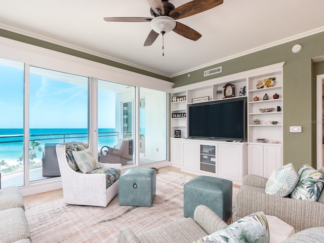 living room featuring visible vents, ornamental molding, ceiling fan, and a healthy amount of sunlight