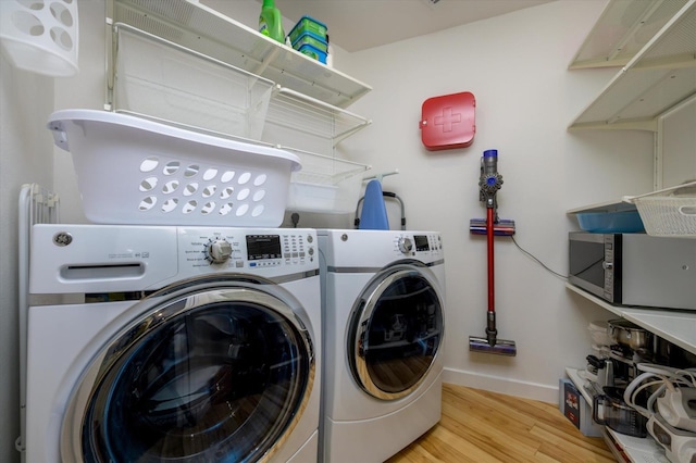 laundry area featuring light wood-type flooring, laundry area, independent washer and dryer, and baseboards